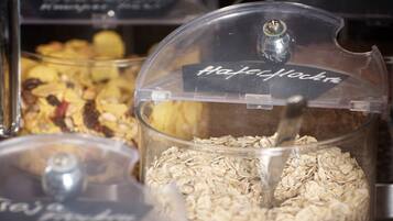 Diversos alimentos em recipientes transparentes com etiquetas, incluindo aveia e granola.