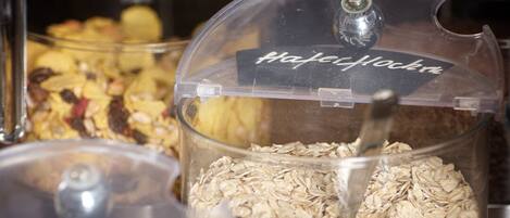 Diversos alimentos en recipientes transparentes con etiquetas, como avena y granola.