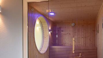 Un interior de madera con un tragaluz circular y un banco de madera.