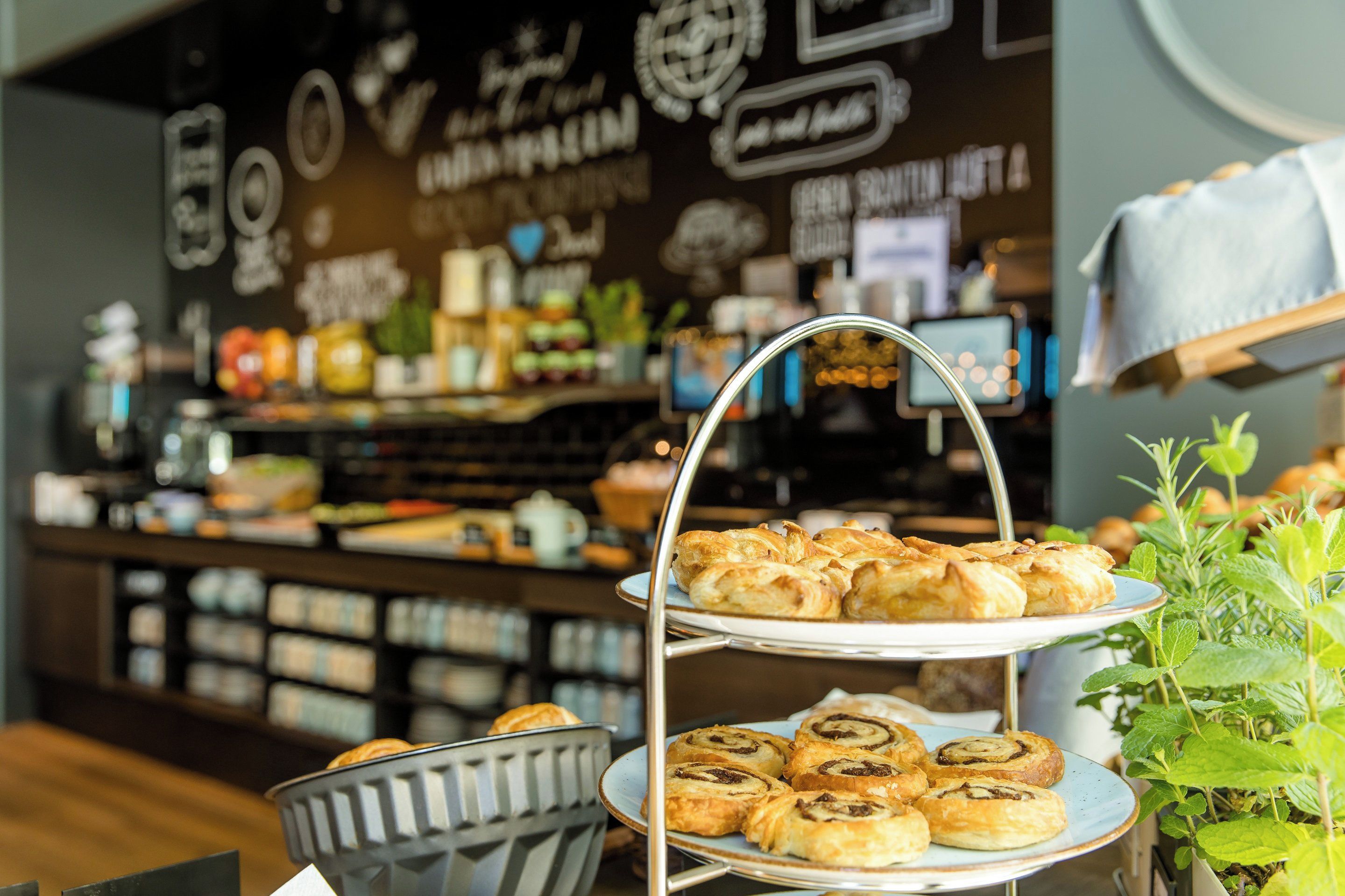 A bakery display with pastries and a coffee machine in the background.