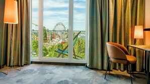 A hotel room with a large window, a desk, a chair, and two floor lamps. - Motel One Wien-Prater (Vienna)