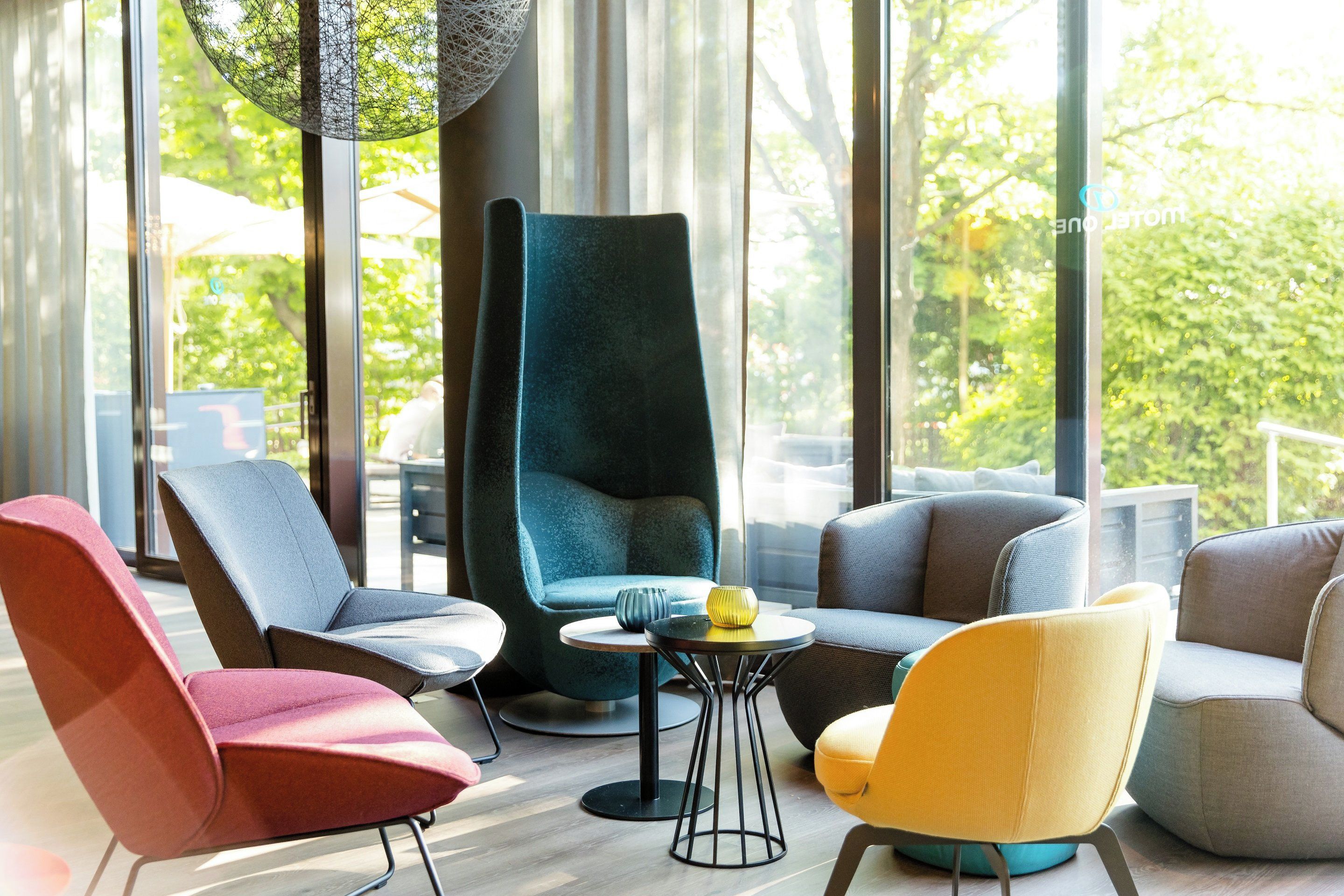 Een moderne loungehoek met verschillende zithoeken, waaronder stoelen en banken, rond een centrale tafel.