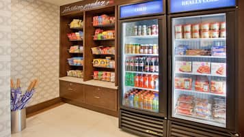 A food and beverage area with snack shelves and refrigerated drink cases.