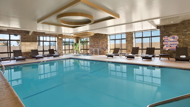 A large indoor swimming pool with lounge chairs and a view of the outside. - Hampton Inn Los Angeles Int'l Airport/Hawthorne (Hawthorne)
