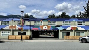 Un motel con un toldo colorido y un letrero que dice "AUGUST JACK MOTORINN".