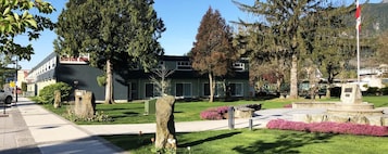 A building with a sign that reads 'MOTOR INN' and a well-maintained lawn with a stone monument.