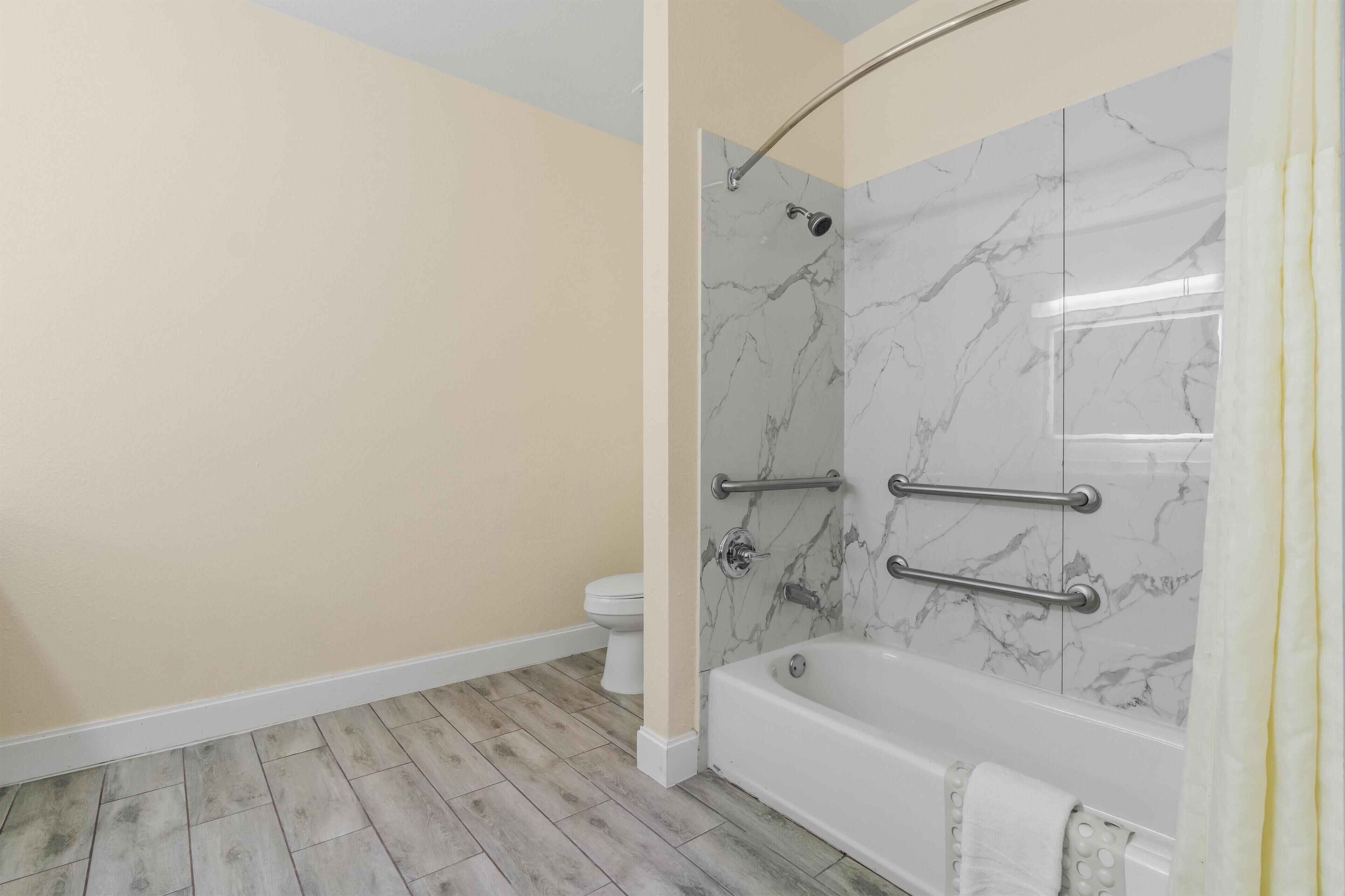 Ein Badezimmer mit Dusche, Toilette und Badewanne.