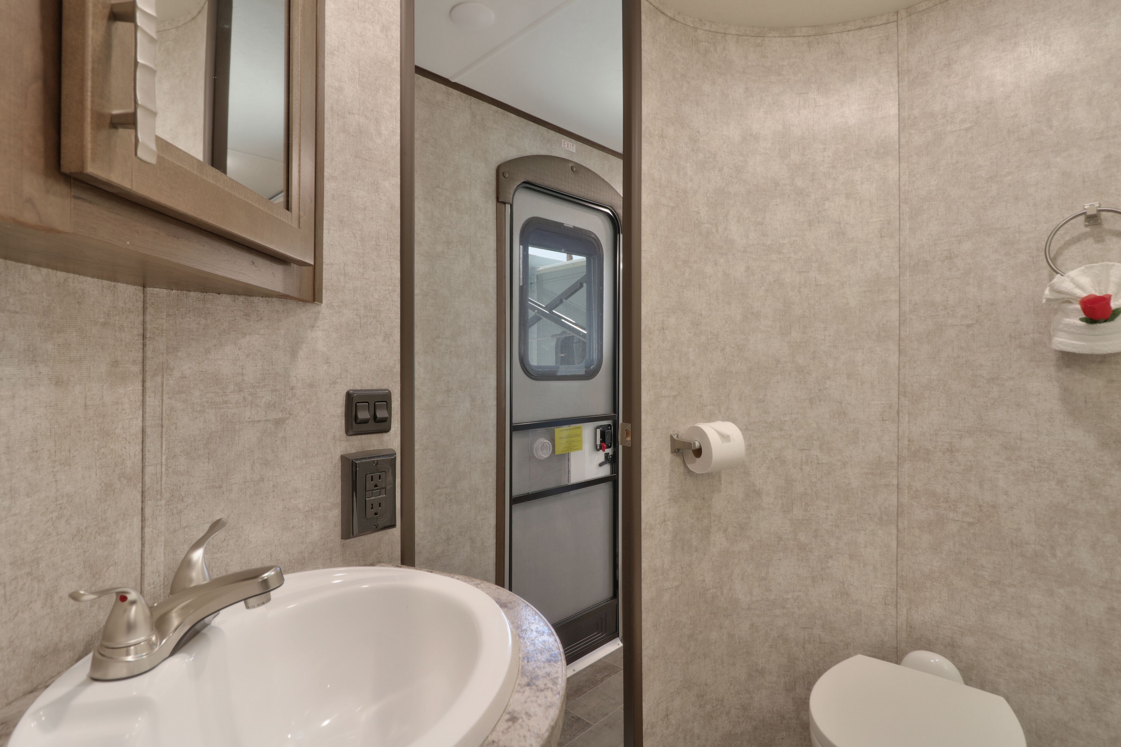 Un baño con lavamanos, inodoro y espejo.