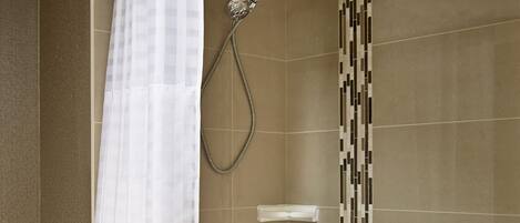 Un baño con bañera, ducha y una toalla colgada en la pared.