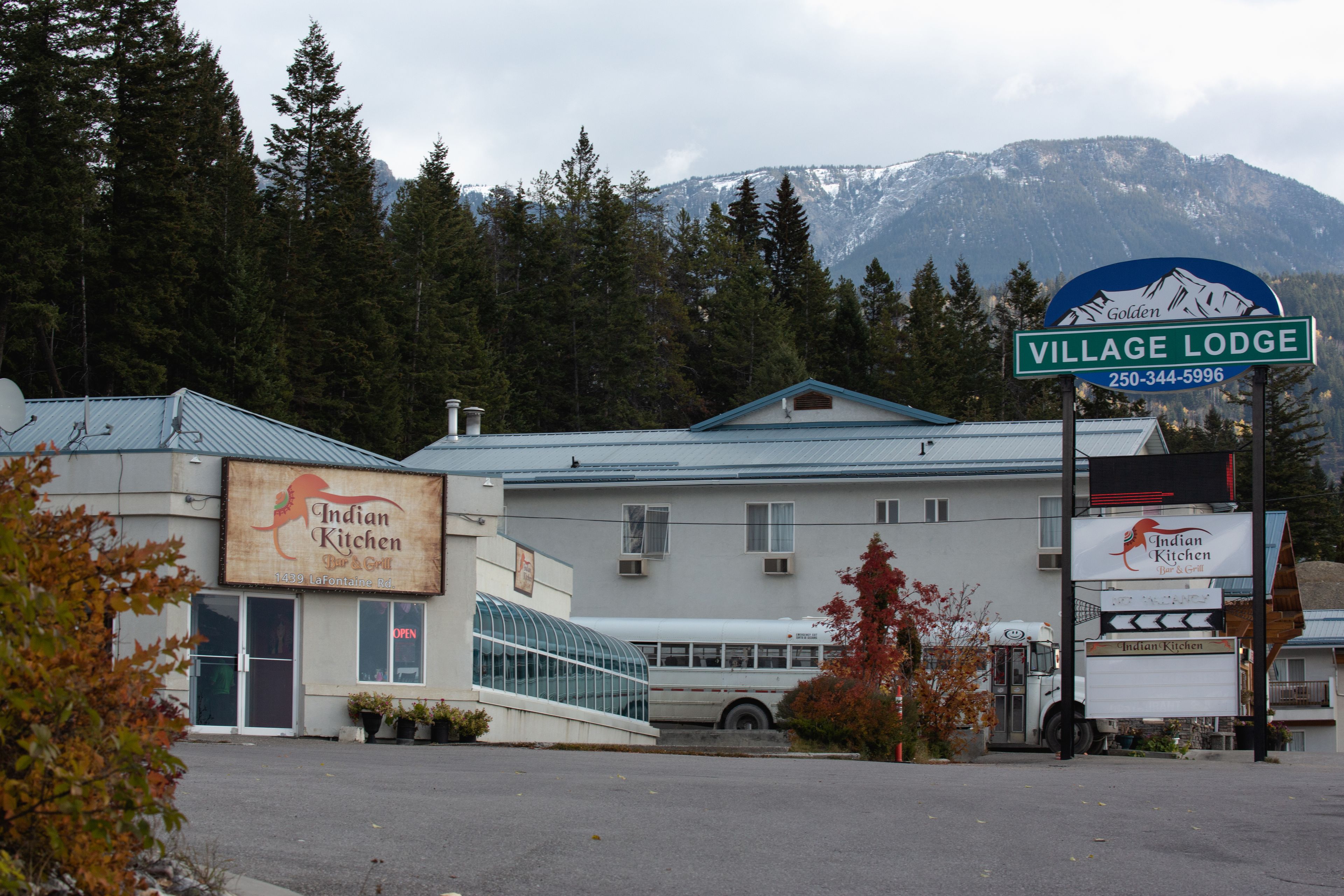 A building with a sign for 'Village Lodge' and 'Indian Kitchen' restaurant.