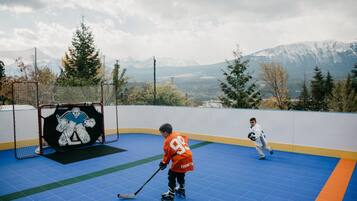 An ice hockey rink with a net, goal, and two players in action.