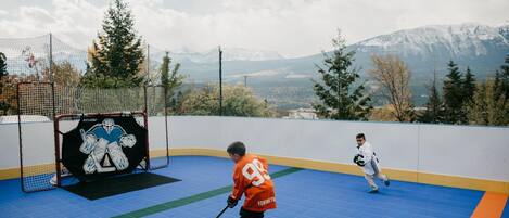 Una pista de hockey sobre hielo con una portería, un gol y dos jugadores en movimiento.