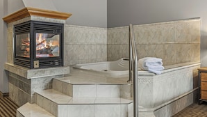 Un baño con chimenea, bañera y zona de ducha.