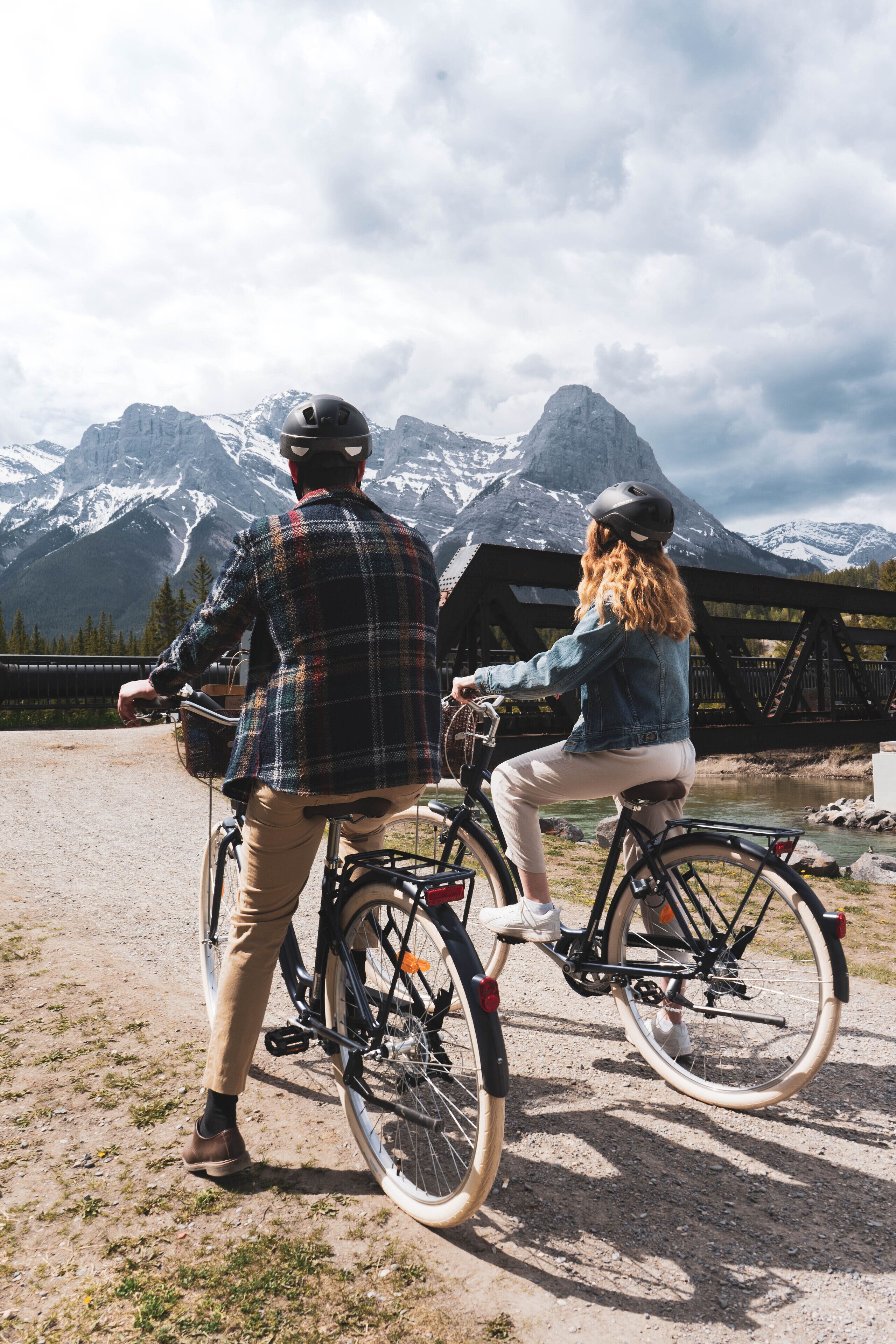 Twee personen op fietsen met een bergachtig landschap op de achtergrond.