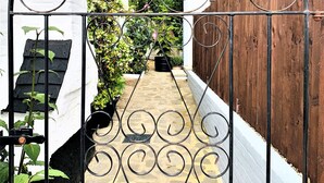 A gated garden pathway with a wrought iron gate, a stone archway, and a brick wall. - The Chequers Inn (Amersham)