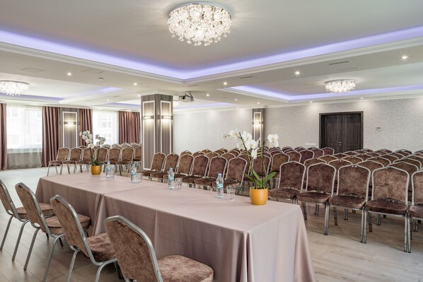 A conference room with a long table, chairs, and a chandelier.