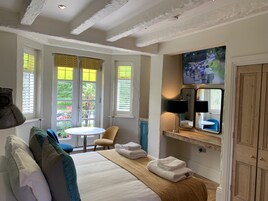 Una habitación de hotel con cama, una silla, una mesa y televisión.