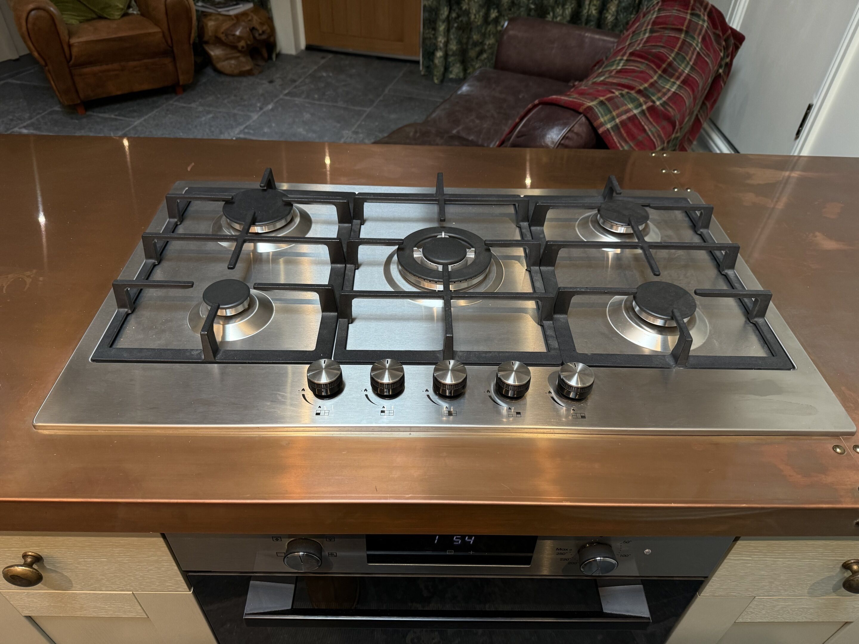 A stainless steel gas stove with four burners and a digital display.