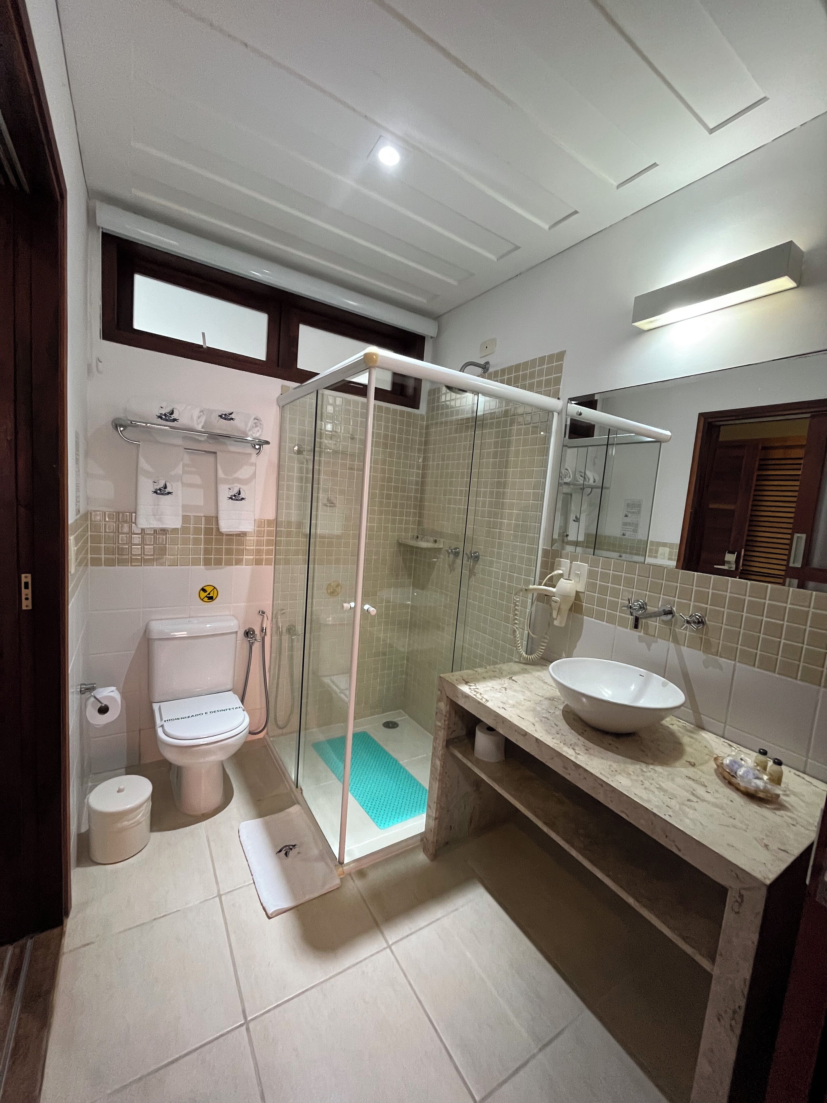 A modern bathroom with a glass-enclosed shower, a toilet, and a sink.