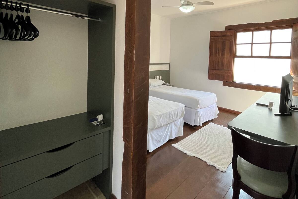 A room with a bed, a desk, and a wardrobe.