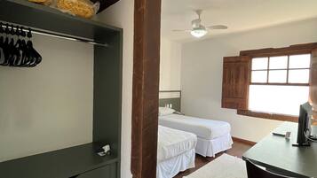 A room with a bed, a desk, and a wardrobe.