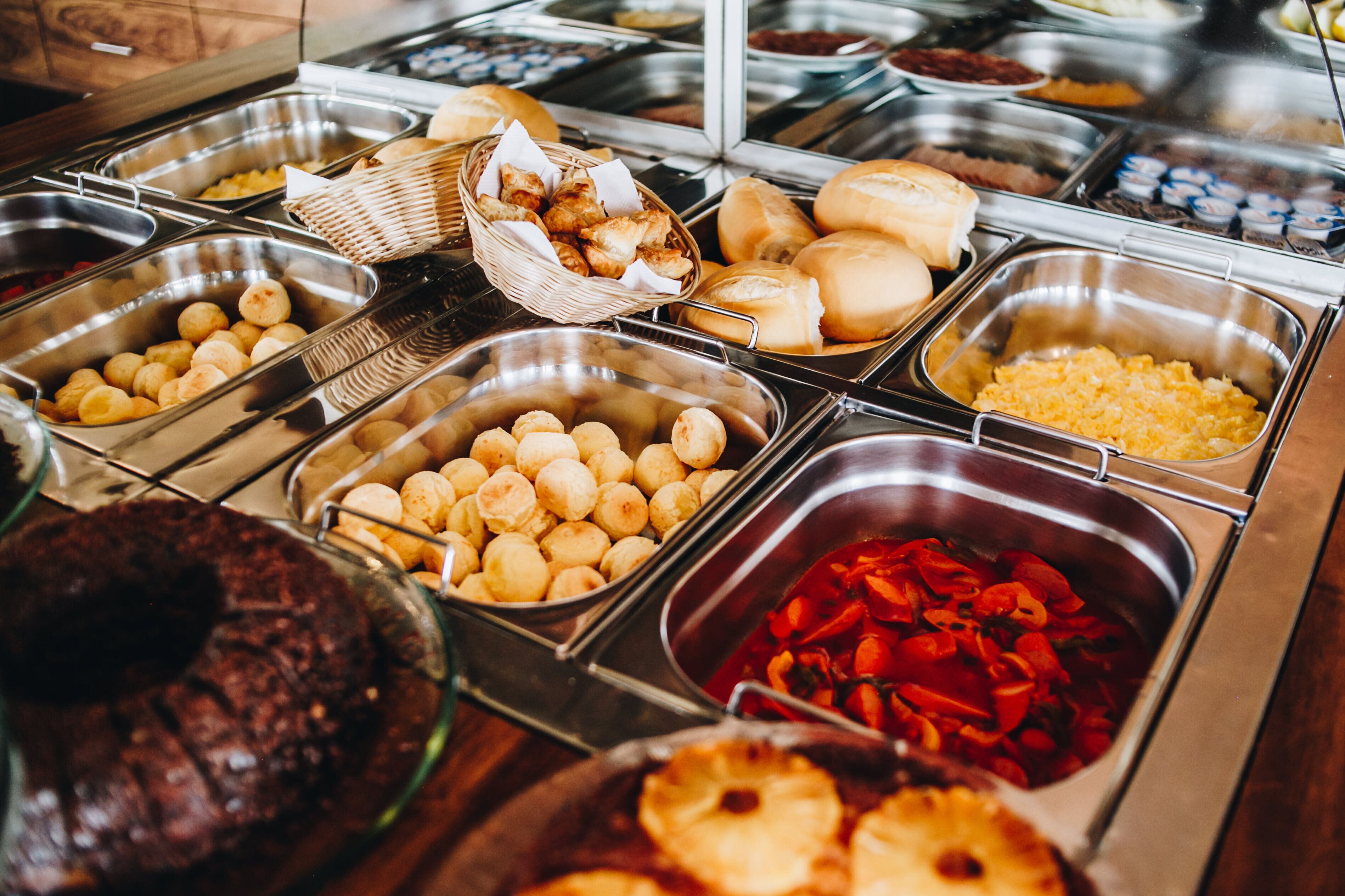 A buffet with various food items including bread, potatoes, and a cake.