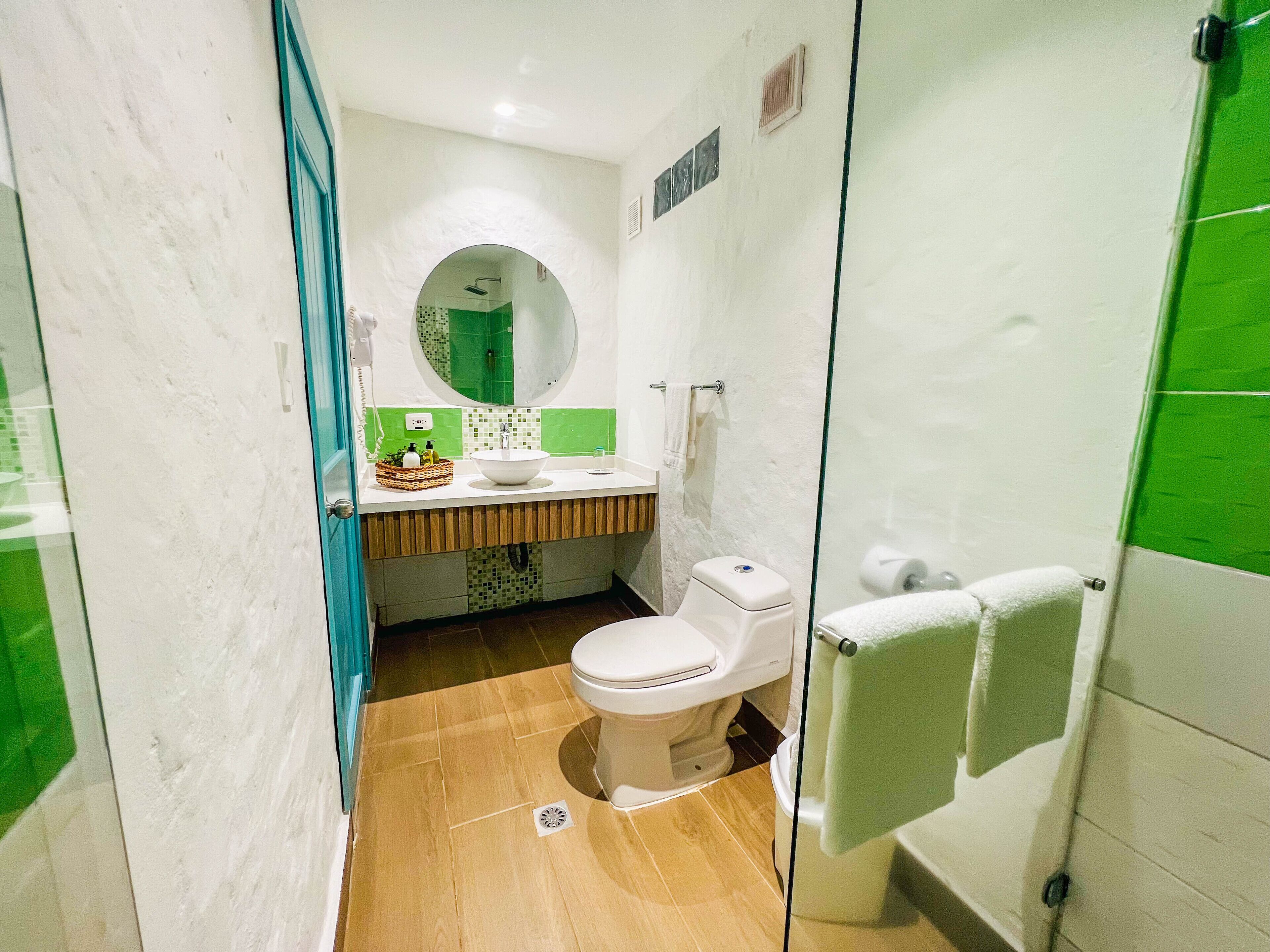 A compact bathroom with a toilet, sink, and shower.