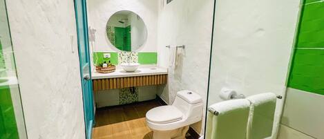 A compact bathroom with a toilet, sink, and shower.