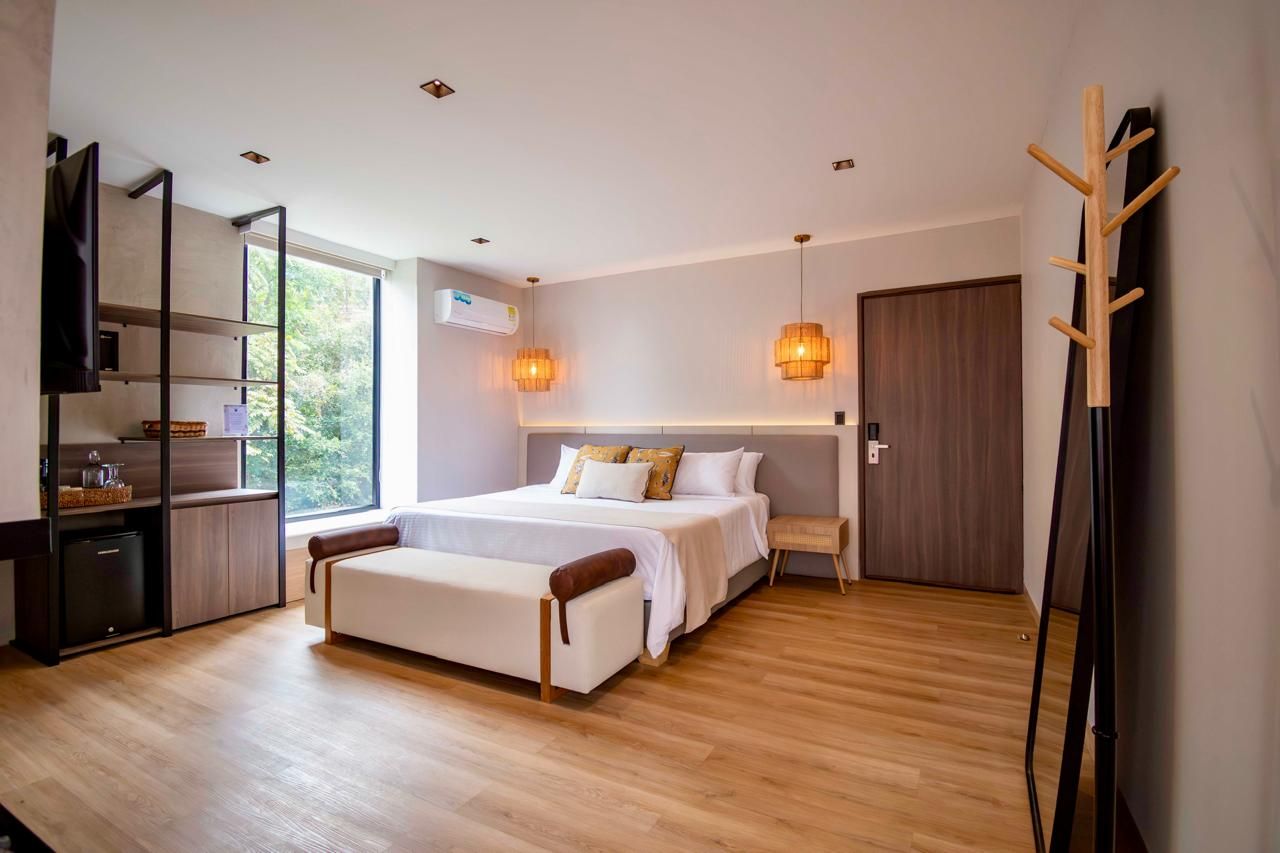Ein modernes Schlafzimmer mit einem Bett, einem Nachttisch und einem an der Wand befestigten Fernseher.