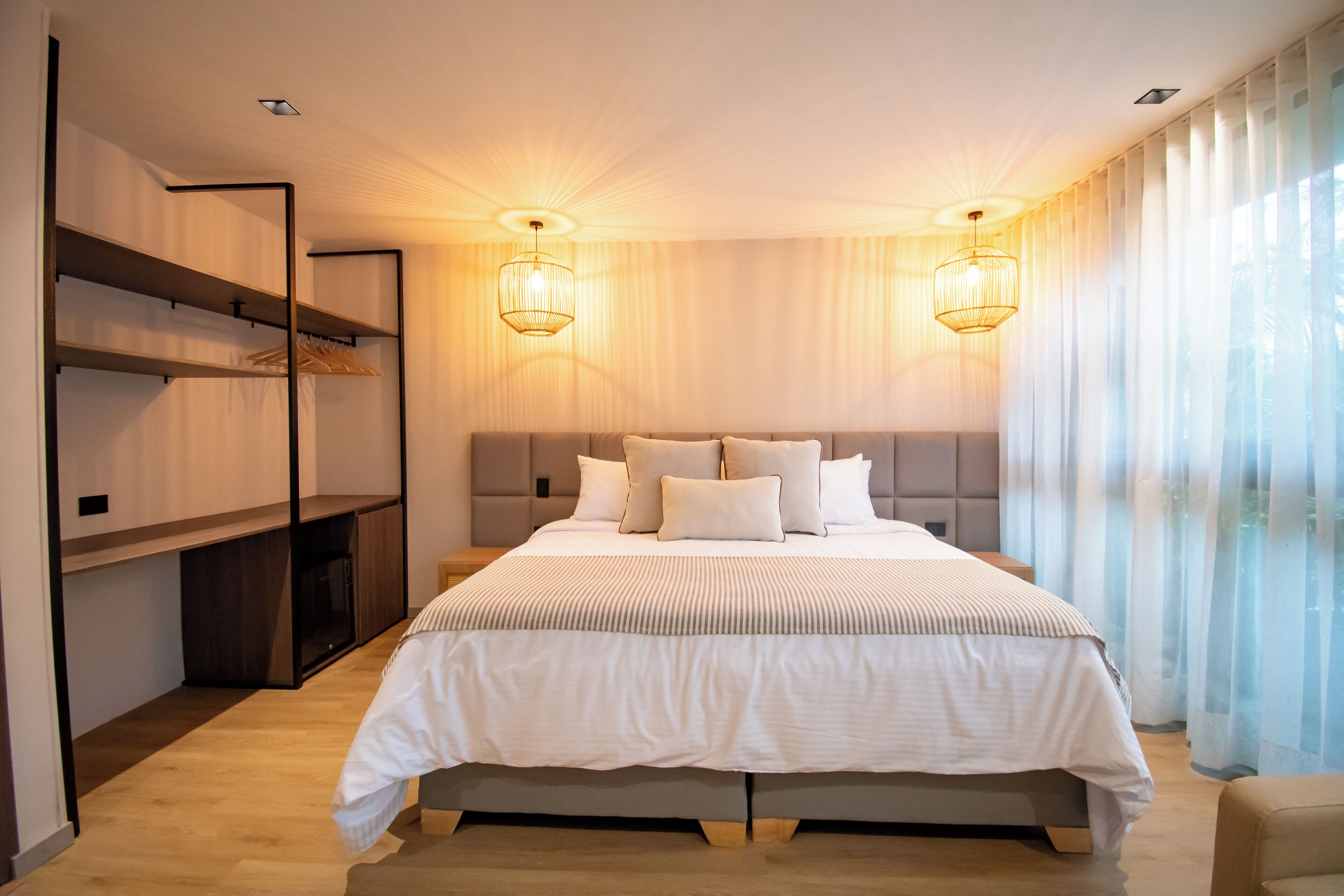 Une chambre moderne avec un grand lit, des étagères intégrées et deux lampes fixées au mur.