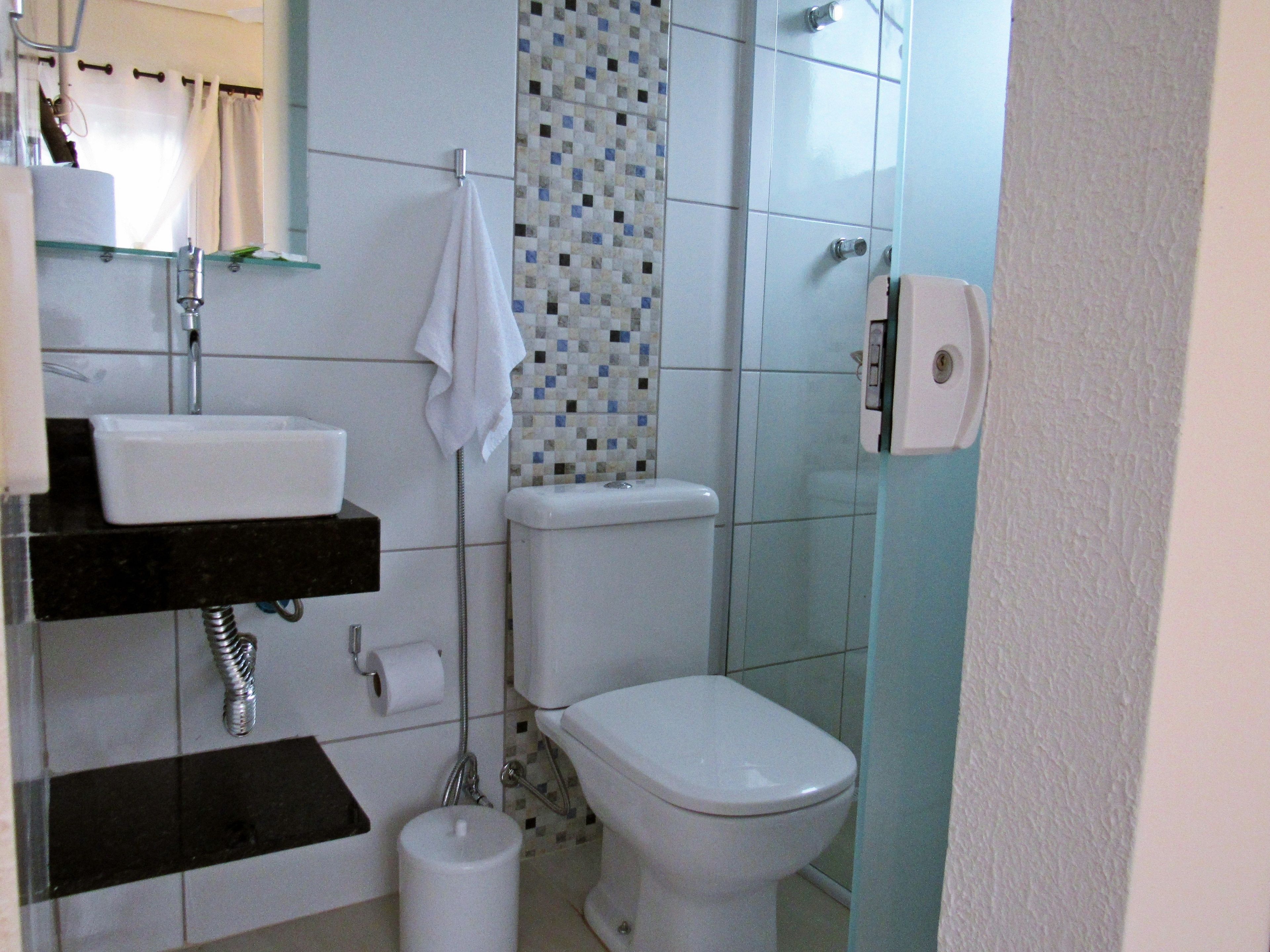 A bathroom with a toilet, sink, and shower.