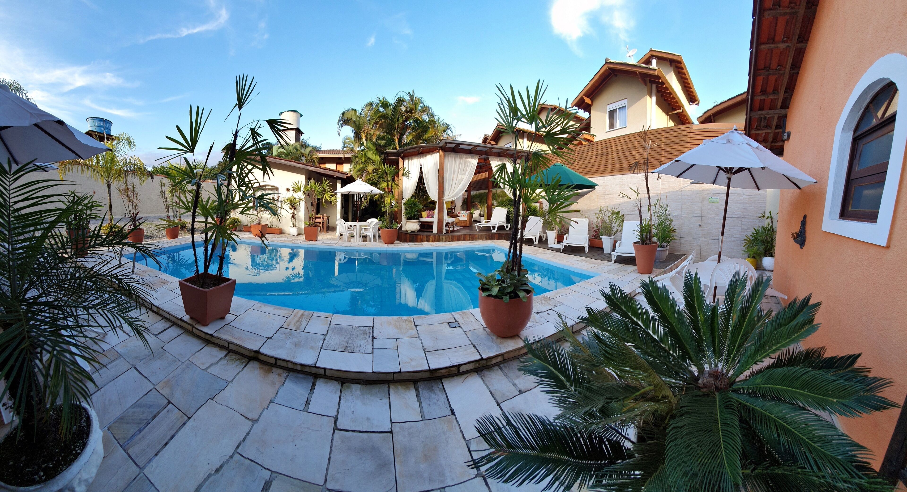 Een buitenzwembad, parasols voor strand/zwembad