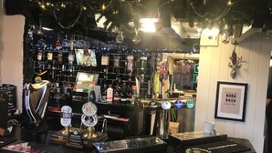 A bar area with a counter displaying beer taps, a selection of bottles, and a framed quote on the wall. - The Oddfellows Arms (Leeds)