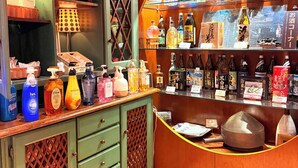 A bar area with shelves of bottles and a counter with various items. - Hotel Gasthof (Kagoshima)