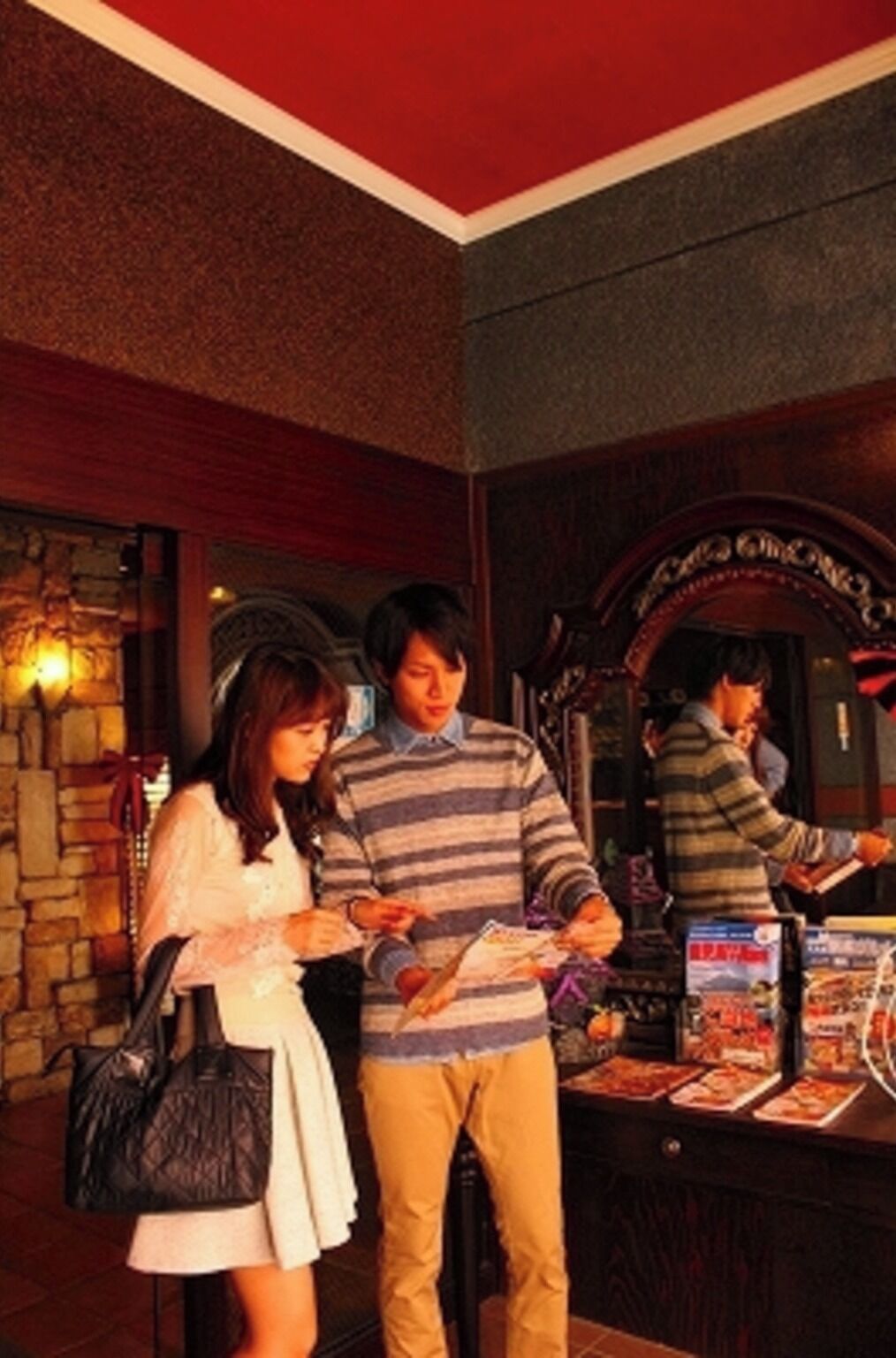 A bar area with a stone wall, a mirror, and a counter with menu items.
