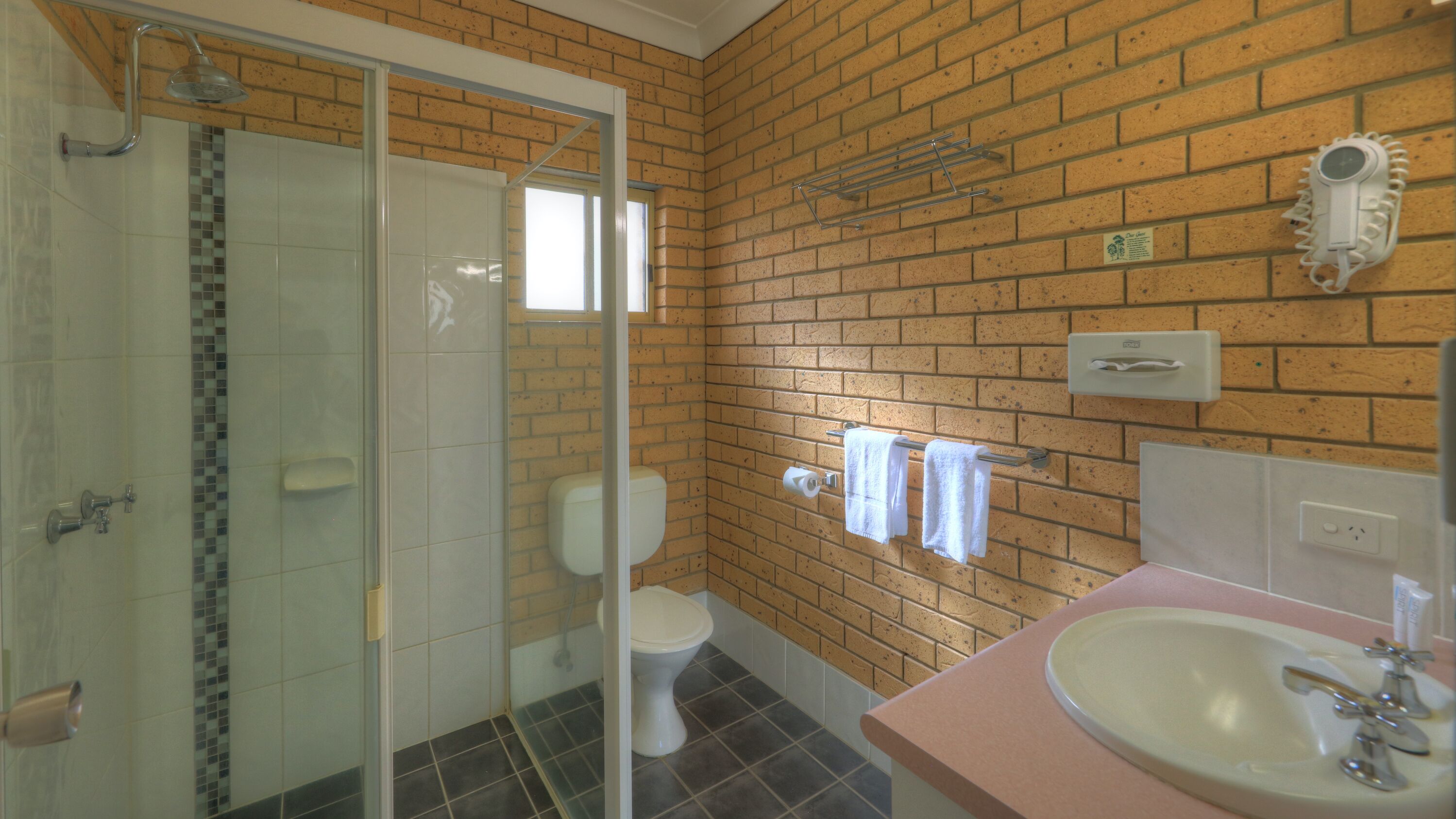 A bathroom with a shower, toilet, and sink.