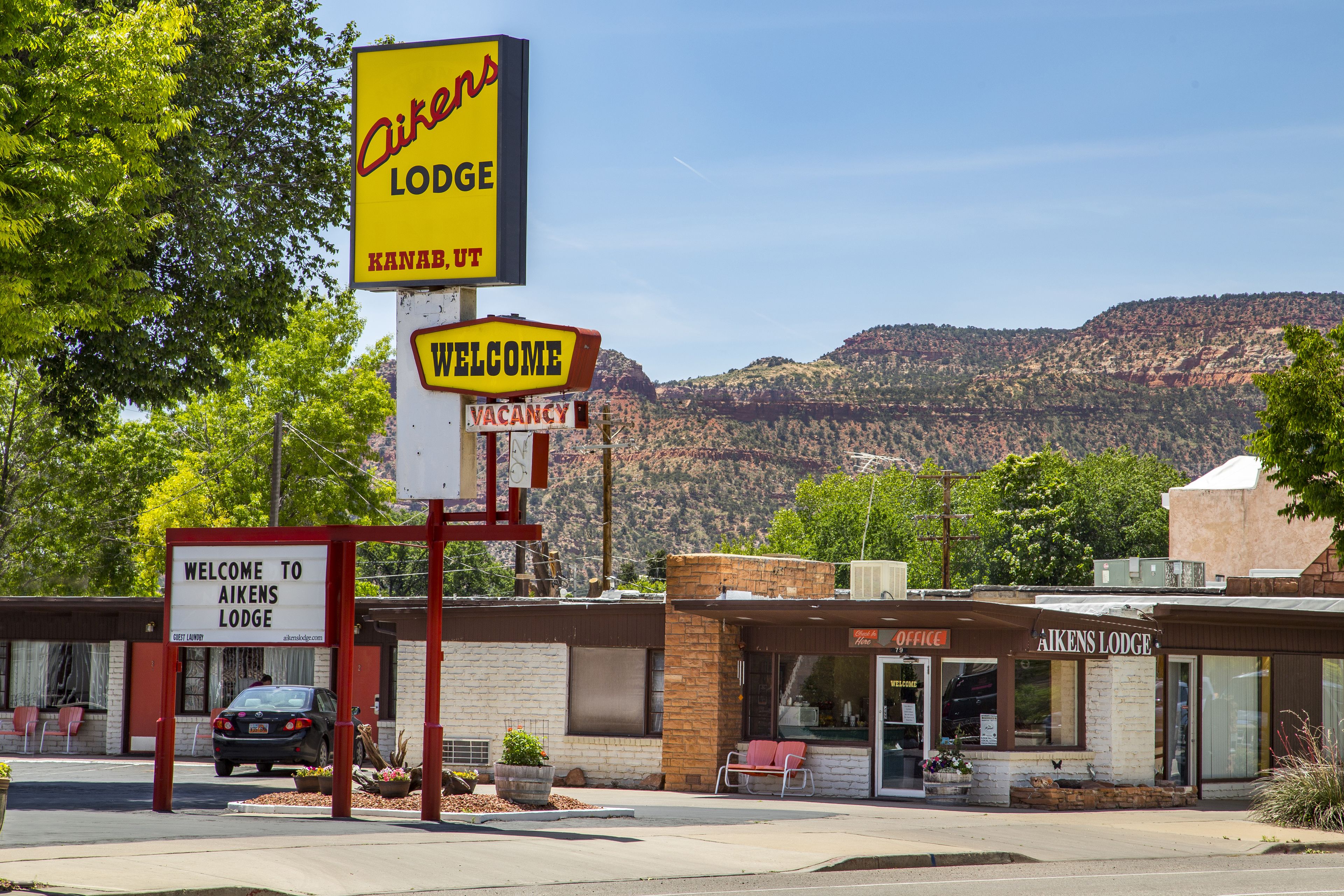 A building with a sign reading "Aiken's Lodge" and "Welcome to Aiken's Lodge."