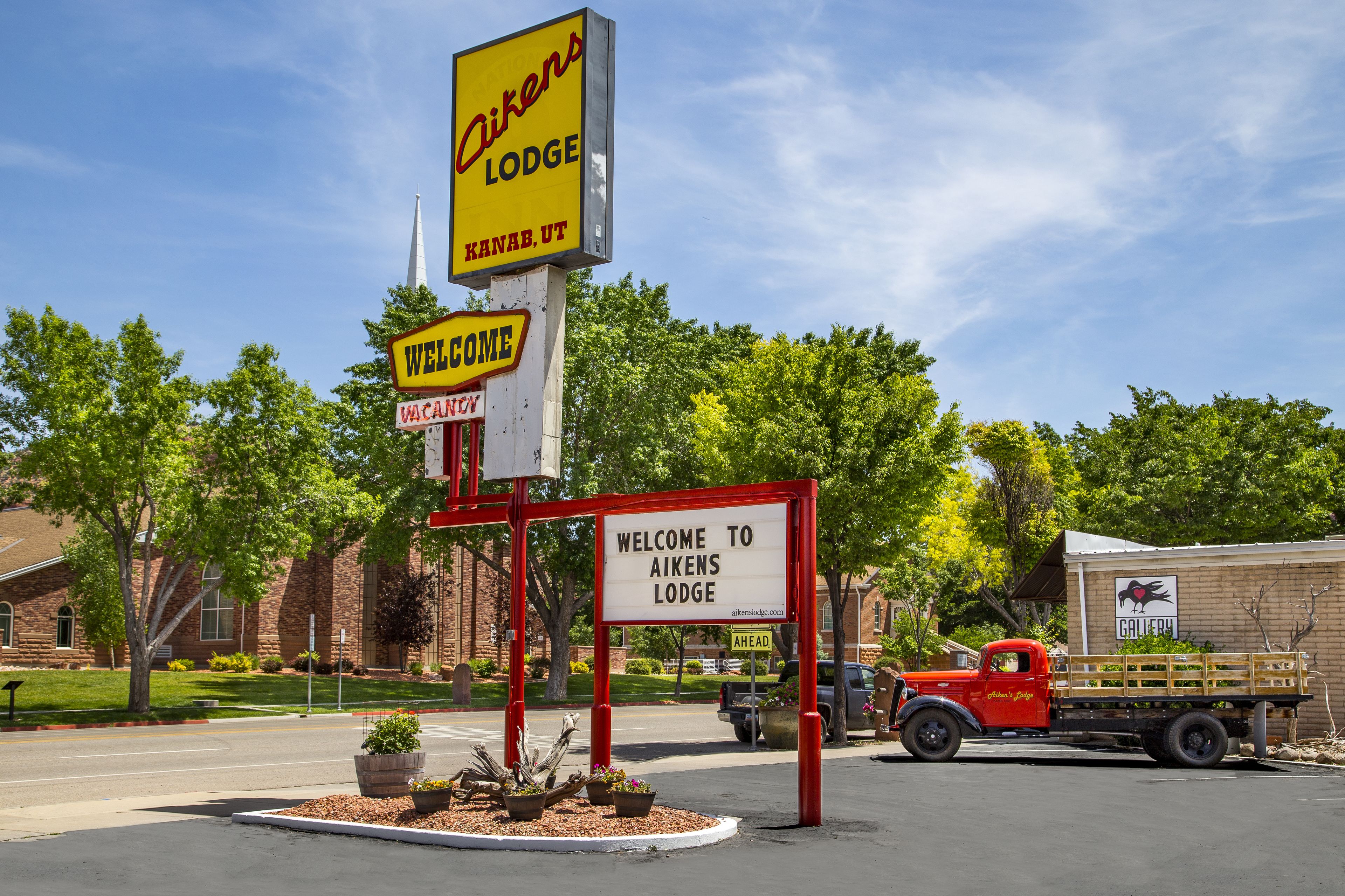 A motel sign with "Welcome to Aikens Lodge" and "Kanab, UT" visible.
