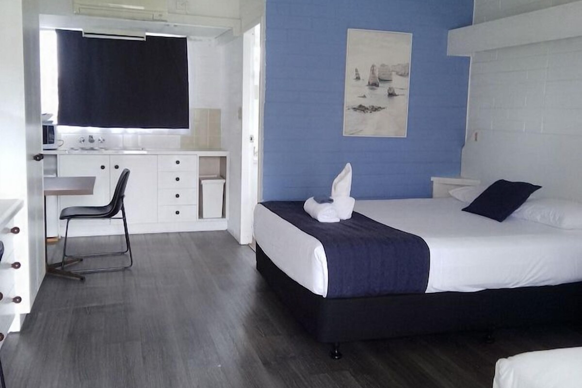 Ein Hotelzimmer mit einem Bett, einem Schreibtisch und einem Stuhl.