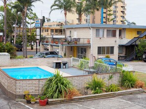 A hotel with a pool, outdoor seating, and a sign advertising a motel and motor inn.