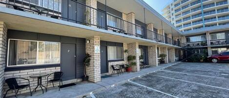 Un motel à plusieurs étages, doté d’une terrasse et d’un parking.