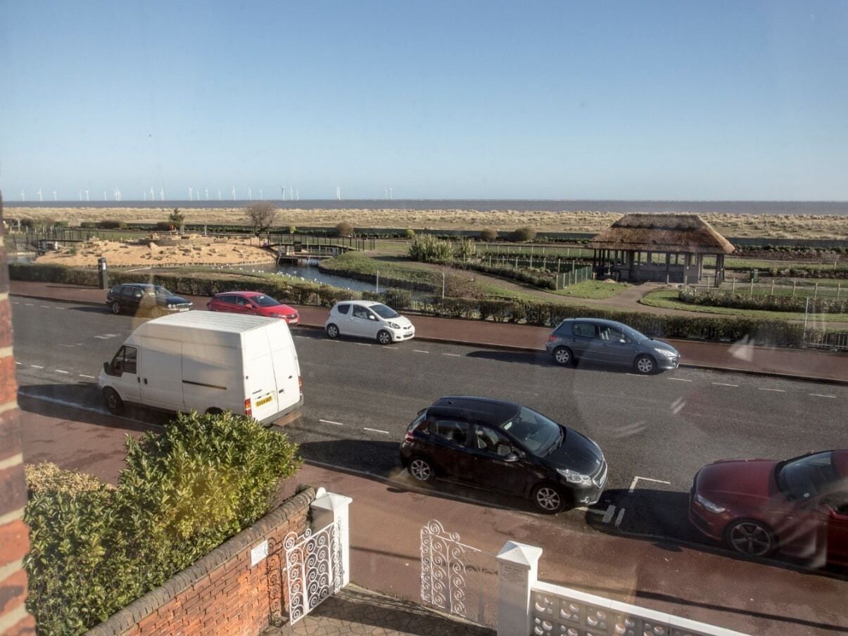 A parking lot with several cars and a white van.
