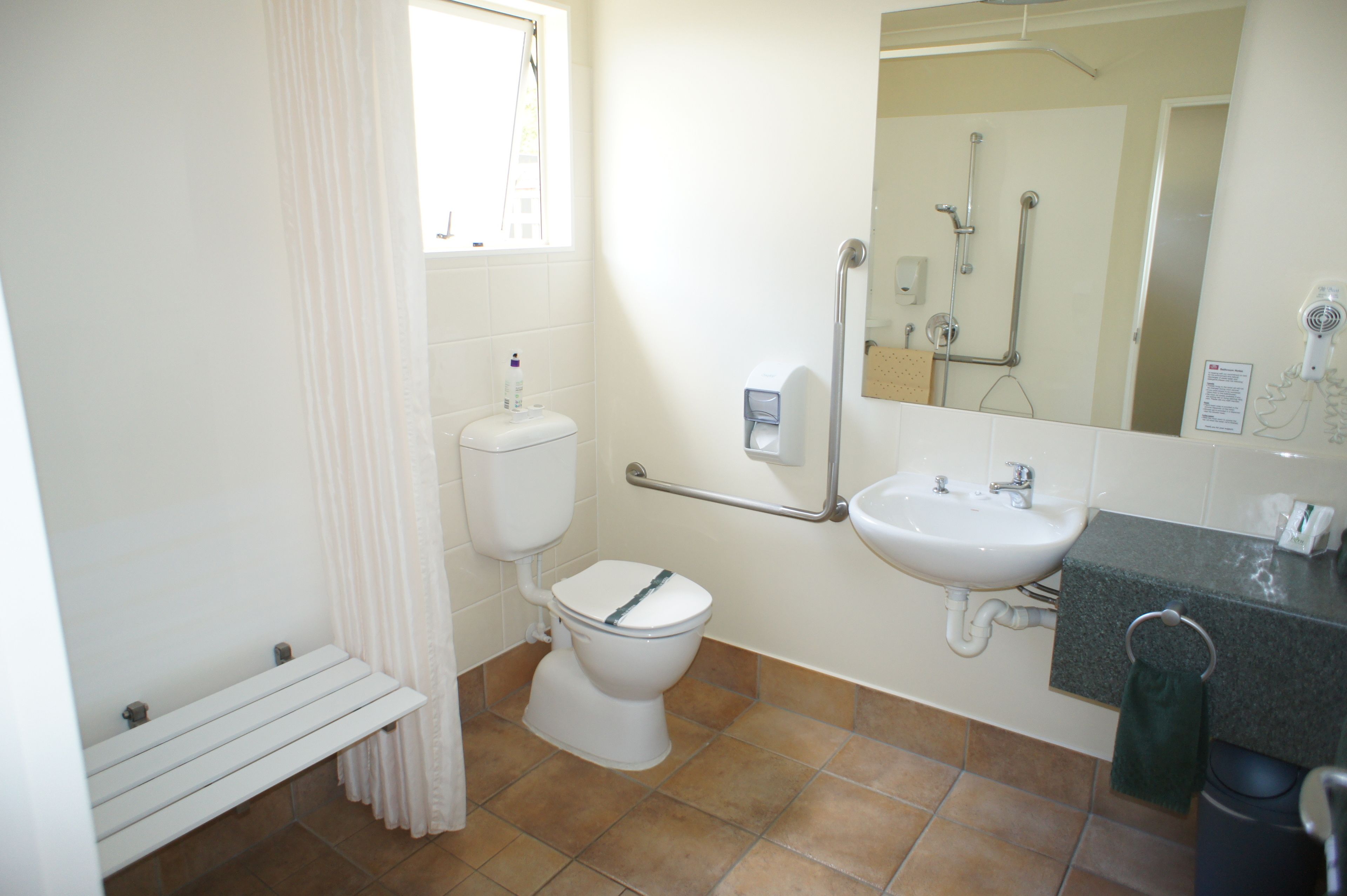 A bathroom with a toilet, sink, and shower.