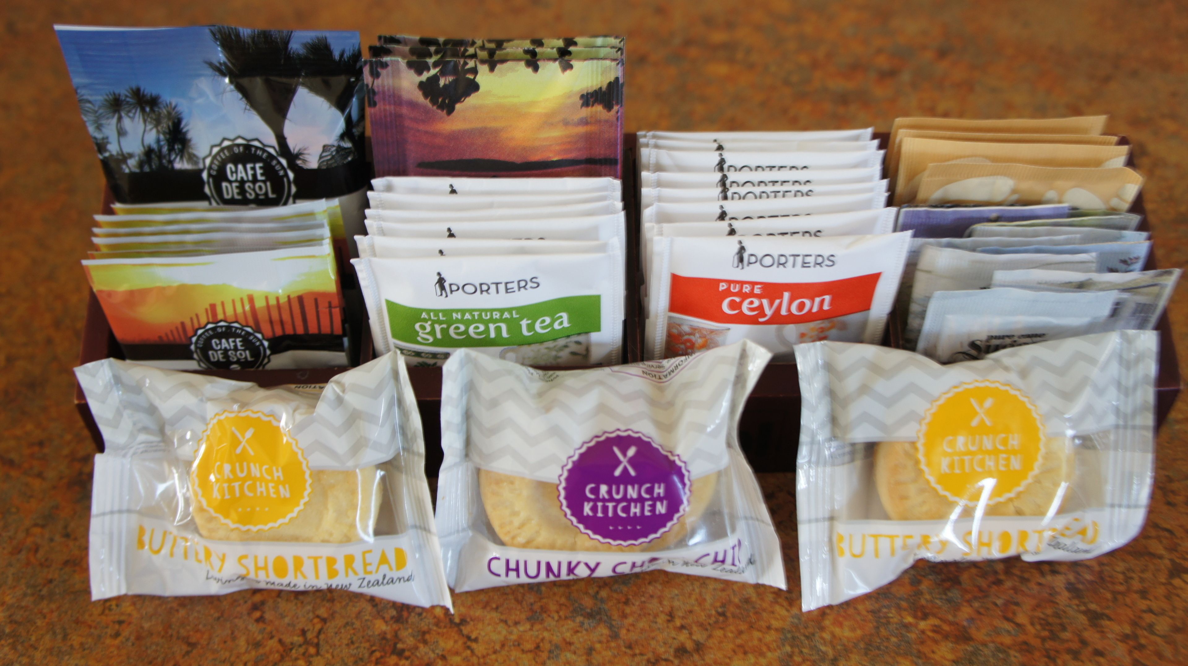 A variety of packaged food items including green tea, butter shortbread, and crunchy cookies.