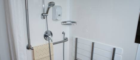 Une salle de bain équipée d’une douche, d’un porte-serviettes et d’un sèche-mains.
