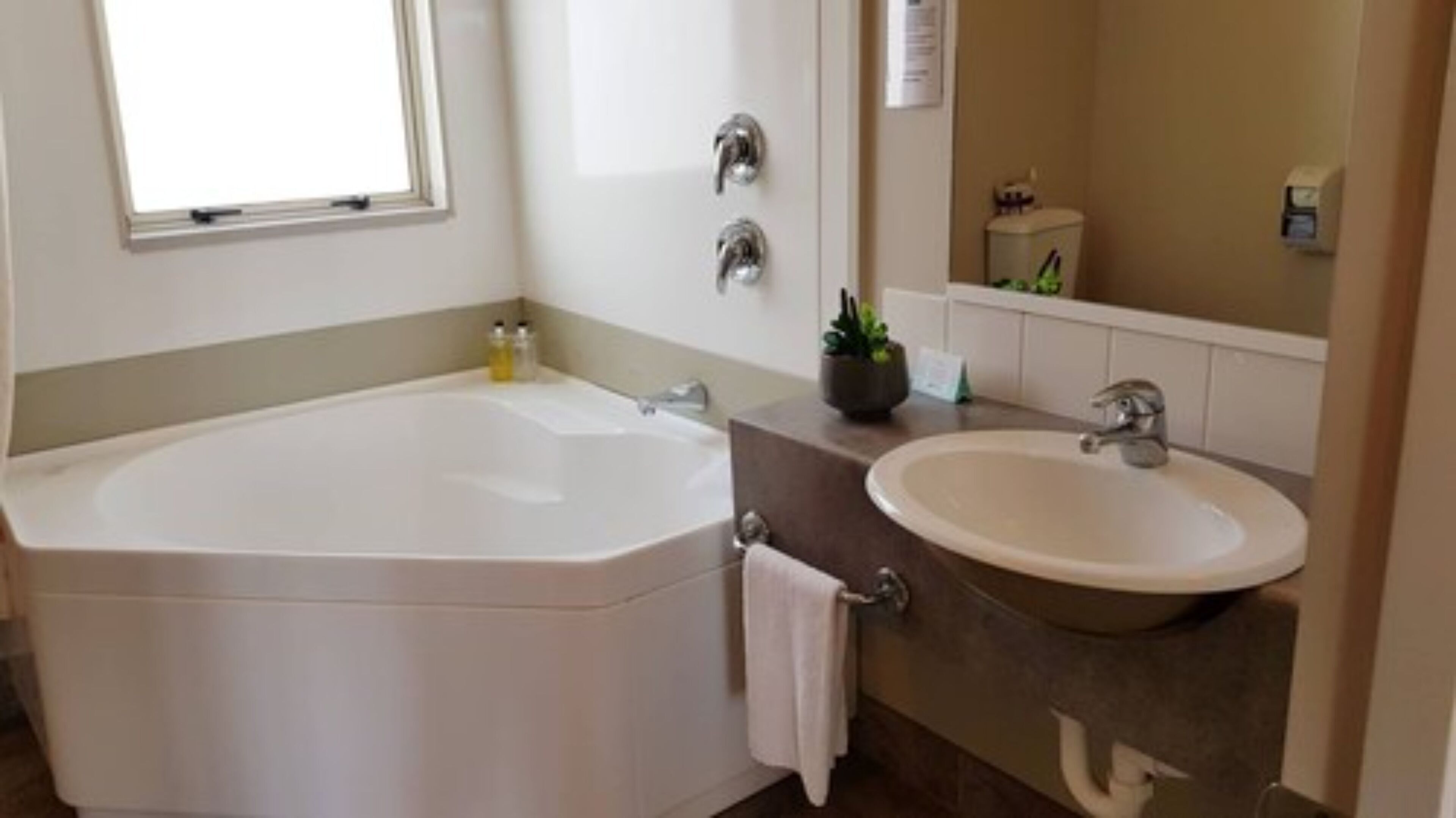 Une salle de bain avec une baignoire, un lavabo et un miroir.