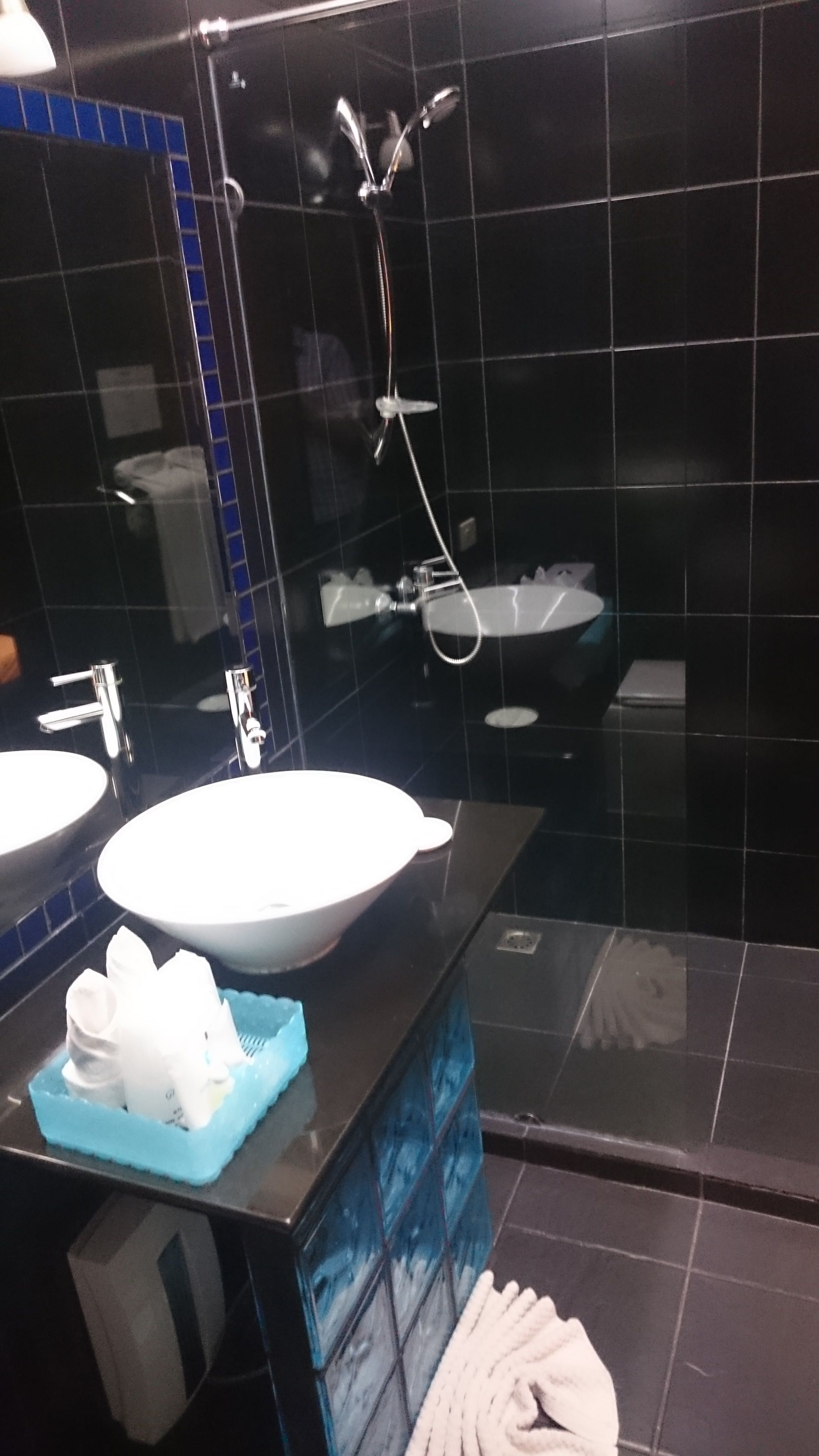 A modern bathroom with two sinks, a mirror, and a shower.