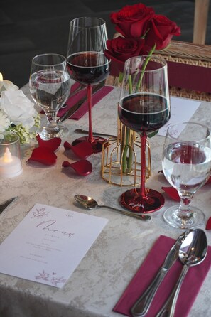 A table set with wine glasses, rose petals, and a menu. - La Villa Langkawi - Private Pool (Langkawi)