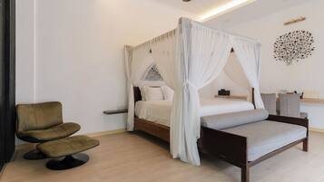 A bedroom with a four-poster bed, a bedside table, a chair, and a ceiling fan.