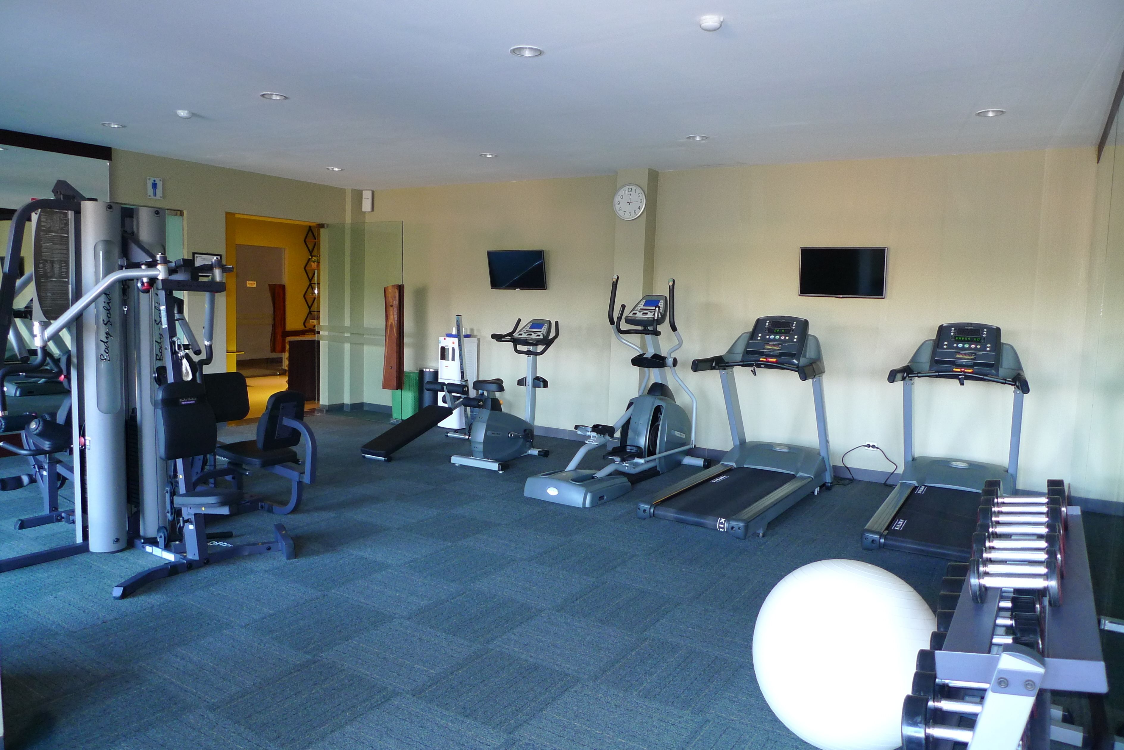 A gym with treadmills, elliptical machines, and weight machines.